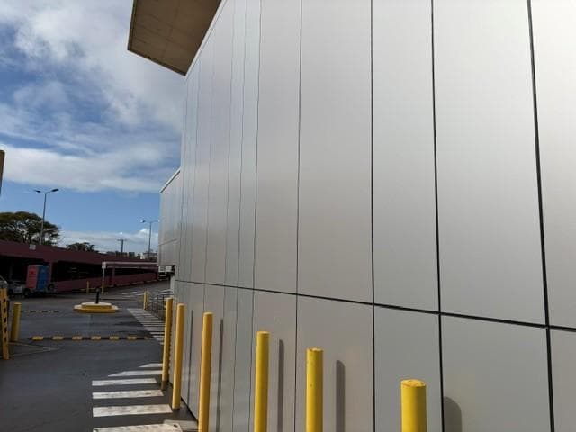 Close-up of ALPOLIC™ metallic cladding with yellow protective bollards