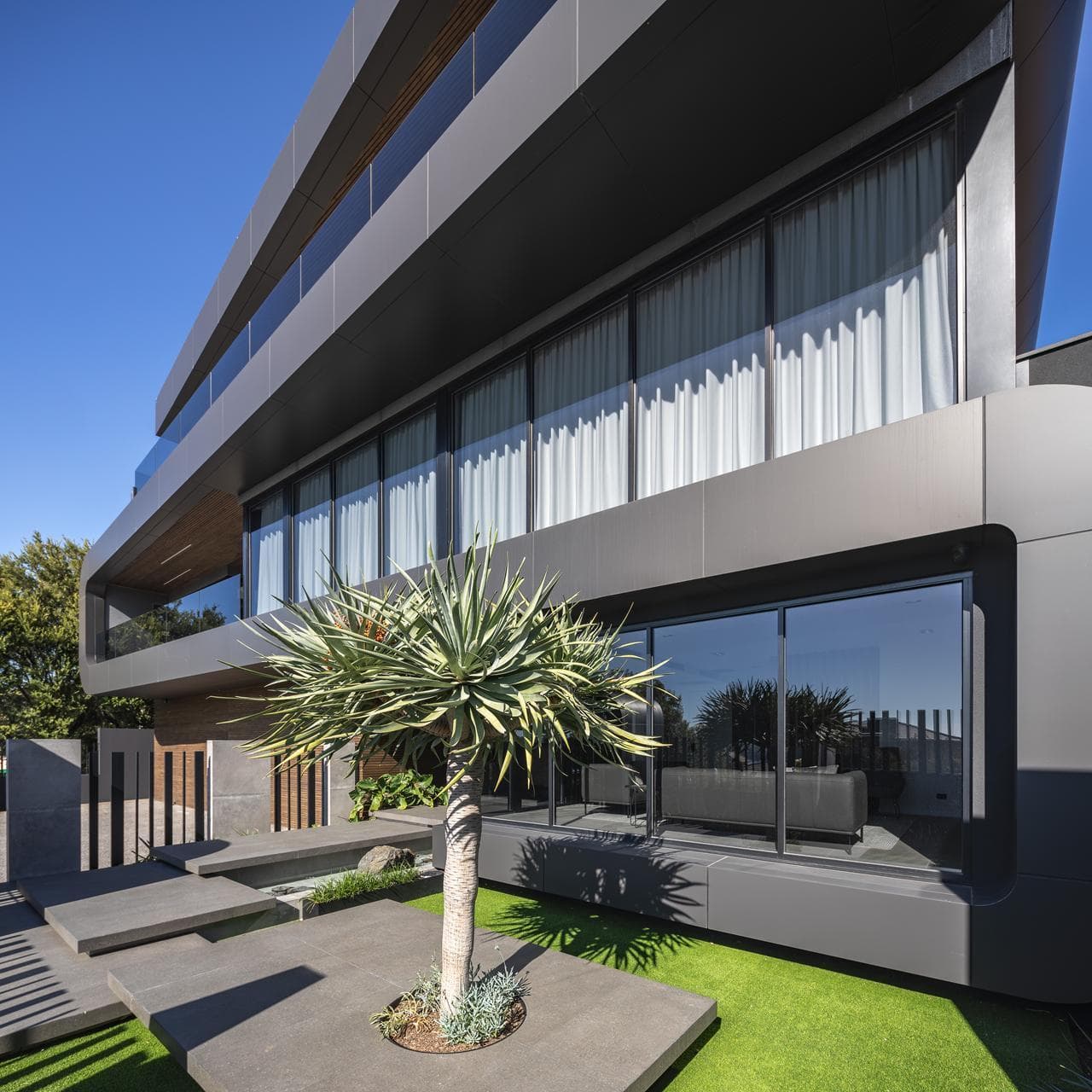 Close-up of ALPOLIC™/fr Matte Slate Black cladding detail with landscaping at 9 Stoke Street residence